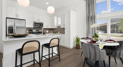 Model kitchen and dining room at Everleigh Vernon Hills 55 plus community in Vernon Hills, IL, featuring wood grain flooring.