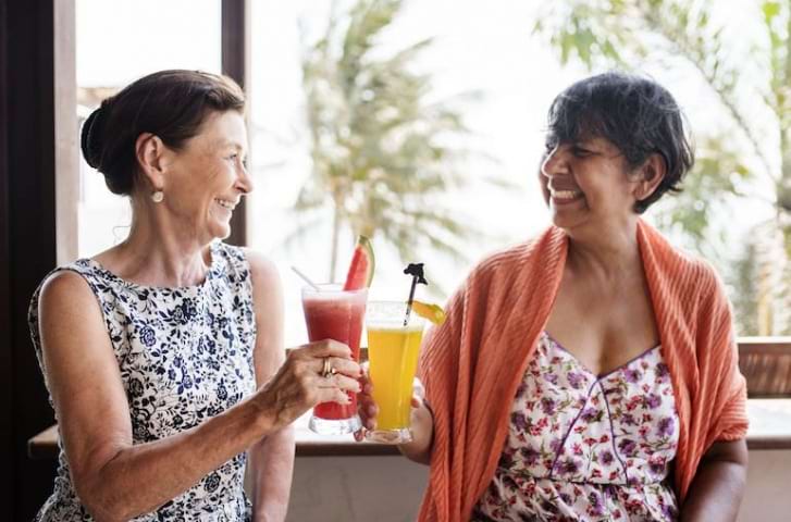 carefree two old women are drinking cocktails