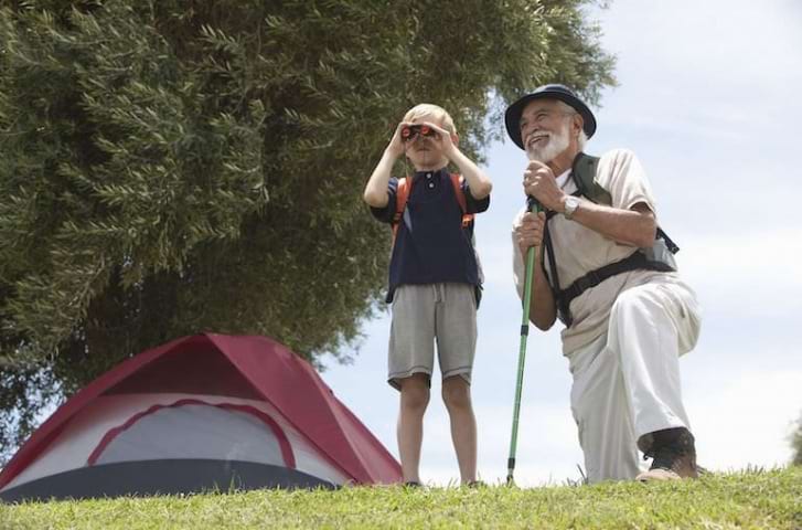 Smiling grandpa and grandson outside