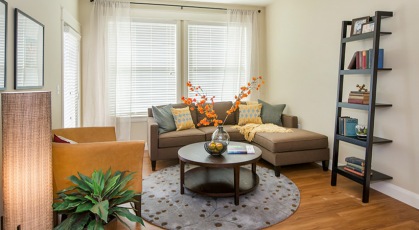 cozy living room with large, bright windows and private patio access