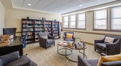 library brightened by large windows and recessed lighting