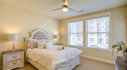 carpeted bedroom with large windows and ceiling fan