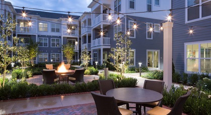 stringed lighting above courtyard with seating areas and fire pit