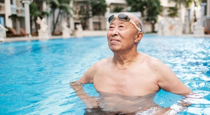 old man stnading in pool with his hands on his hips