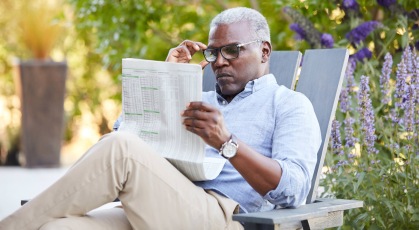 man reading a newspaper outdoors