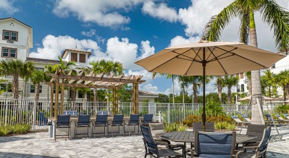 shaded tables and chairs next to outdoor grills