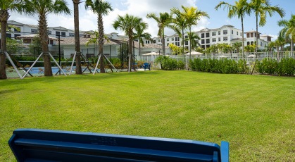 benches on grass lawn next to pool and pickleball court