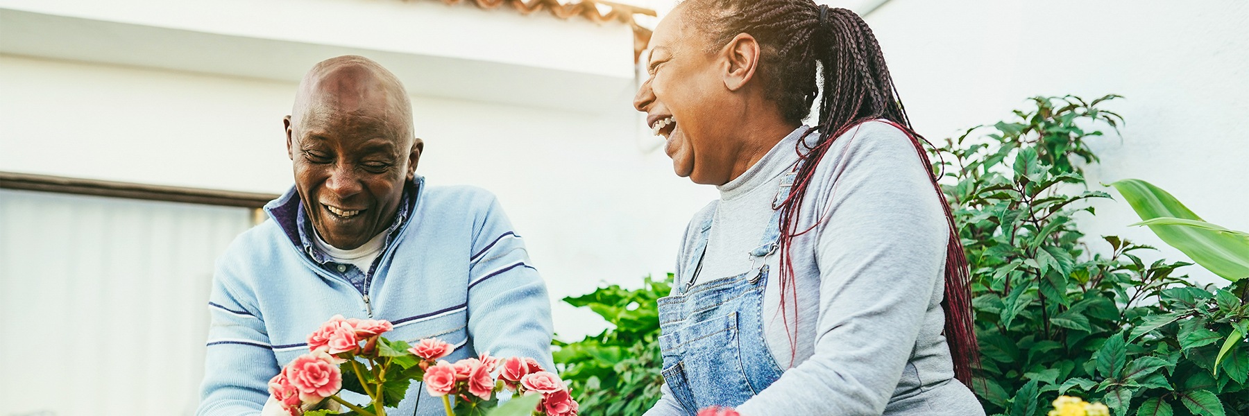 a couple smiling and gardening together