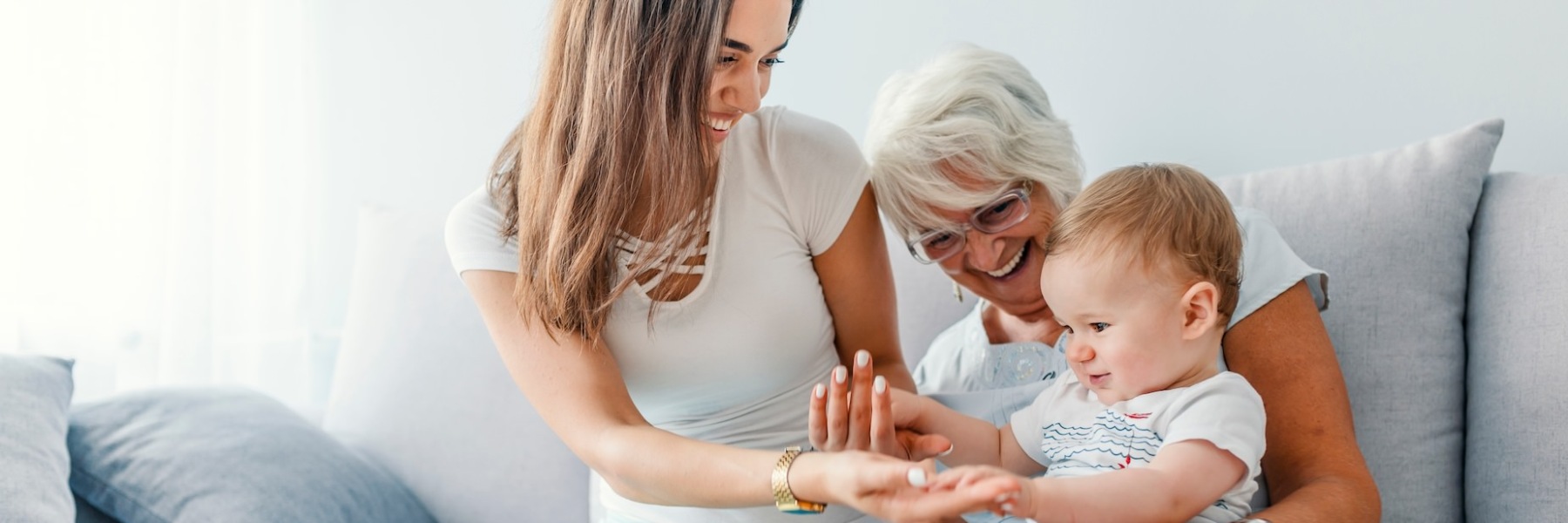 A family smiling and playing with a baby at Everleigh Duluth senior living apartments in Duluth, GA.